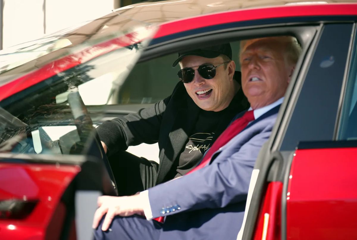 A photo of Donald Trump and Elon Musk sitting inside of a red Tesla